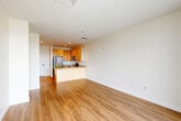 This 1-bedroom, 1-bathroom unit in Boston's 02210 zip code offers a well-designed, single-floor layout that maximizes functionality. The open-concept living area is anchored by light hardwood flooring that flows throughout, creating a bright and cohesive feel. Large floor-to-ceiling windows flood the living and dining space with natural light while framing views of the surrounding cityscape.

The kitchen is thoughtfully appointed with light maple cabinetry, granite countertops, and a full suite of stainless steel appliances including a refrigerator, electric range, built-in microwave, and dishwasher. A peninsula with a sink and additional counter space serves as a natural divider between the kitchen and the living area, offering both a prep station and casual dining potential.

The bedroom features plush carpeting, a large window with city views, and access to a closet. The full bathroom includes a tiled tub-shower combination with clean, modern finishes and tile flooring. Additional conveniences include an in-unit laundry area, a utility room, and two closets for ample storage. The neutral color palette throughout creates a clean, move-in-ready environment well-suited for urban living in Boston.
