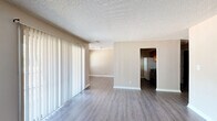This single-story, three-bedroom, two-bathroom home in Macon, Georgia offers a practical and functional layout across its well-organized floor plan. The living and dining areas are finished with durable wood-look flooring and feature large sliding glass doors fitted with vertical blinds, allowing natural light to fill the space while providing outdoor views. A textured ceiling runs throughout the home, adding a classic residential character.

The kitchen is designed with a pass-through counter topped with granite-style laminate, warm wood cabinetry extending to the ceiling, a double-basin sink, a black range, and a full-size refrigerator — offering ample storage and workspace. Adjacent to the kitchen, the dining area connects seamlessly to the living space for easy flow.

Each of the three bedrooms is carpeted for comfort, with neutral beige walls and windows that invite natural light. The primary bedroom includes a closet with bifold wood-panel doors and direct access to a private bathroom. The secondary bedrooms are well-proportioned, with one featuring dual windows. Three closets throughout the home provide generous storage.

Both bathrooms are cleanly appointed, with one featuring a full tub-shower combination, chrome fixtures, a vanity, and dark wood cabinetry. A utility room and hallway complete this efficiently designed home.
