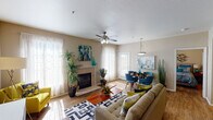 This single-story residence offers a well-designed layout with a variety of functional spaces throughout. The open-concept living and dining area serves as the heart of the home, featuring wood-style flooring, a ceiling fan with integrated lighting, and a tiled fireplace that anchors the living space. Sheer curtains filter natural light through multiple windows, while a glass-paned exterior door provides direct outdoor access. A dedicated dining area accommodates a full table setting beneath a pendant light fixture.

The kitchen is equipped with rich, dark-stained cabinetry, granite-style countertops, and stainless steel appliances, including a dishwasher. Ample upper and lower cabinet storage maximizes functionality. The flex room, suitable as a home office or secondary sitting area, includes a ceiling fan, wood-style flooring, and a window with outdoor views.

The bedrooms feature ceiling fans, wood-style flooring, and large windows that allow natural light to fill the space. Both bathrooms are finished with dark wood vanity cabinetry, granite-style countertops, and tub-shower combinations. The primary bathroom includes a double-sink vanity and additional overhead storage cabinetry, completing the practical and cohesive design of this residence.