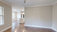 Located at 2905 Chastain Meadows Pkwy in Marietta, GA, this well-appointed 3-bedroom, 2-bathroom single-story home offers a thoughtfully designed layout with quality finishes throughout. A welcoming hallway with hardwood-style flooring and crown molding leads into the open-concept kitchen and living area, which is filled with natural light. The kitchen is a standout feature, showcasing white shaker cabinetry extending to the ceiling, granite countertops, a tile backsplash, a center island, and a full suite of stainless steel appliances. Crown molding accents the living area, adding a refined touch to the open floor plan. The spacious primary bedroom features plush carpeting, a ceiling fan, and multiple windows offering lush outdoor views, complemented by a dedicated closet. Two additional bedrooms provide flexible space, one with carpet and one with hardwood-style flooring, each with ample closet storage. The bathrooms are finished with granite-topped white vanities and hardwood-style tile flooring. A dedicated laundry room houses a full-size washer and dryer with overhead wire shelving. Additional highlights include a pantry, four closets, and a hallway connecting the home's well-organized layout seamlessly.