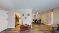 Located at 4837 Columbia Rd in North Olmsted, Ohio, this single-floor residence offers a thoughtfully designed layout that balances comfort and functionality. The living room features warm hardwood-style flooring, neutral taupe walls, and a large sliding glass door with vertical blinds that allows natural light to fill the space. A ceiling fan overhead and a baseboard heating system ensure year-round comfort in this relaxed yet well-appointed area.

The adjacent dining space is defined by a ceiling-mounted pendant light and a ceiling fan, anchored by a wooden dining table with seating for multiple guests. A decorative round mirror adds visual depth to the dining wall. The open sightline connecting the living, dining, and kitchen areas creates a cohesive and spacious feel throughout.

The kitchen is well-equipped with white shaker-style cabinetry, gray countertops, a stainless steel refrigerator, dishwasher, and a subway tile backsplash. Hardwood-style flooring continues here, complementing the clean, modern aesthetic.

The bedrooms feature plush carpeting, neutral walls, and windows that bring in natural light. The bathroom is finished with a white vanity countertop, large mirror, and bright overhead lighting, offering a clean and functional space. Overall, the unit presents a cohesive, move-in-ready interior.