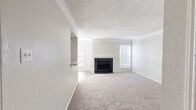 This single-story, 2-bedroom, 2-bathroom home offers a thoughtfully designed layout across a comfortable footprint. The open-concept living room serves as the heart of the space, featuring a striking black tile fireplace with a white mantel as its focal point, framed by multiple windows that invite natural light. Crown molding adds an elegant finishing touch, while plush carpeting underfoot creates a warm and inviting atmosphere.

The galley-style kitchen connects seamlessly to the living area and is equipped with white cabinetry, granite-style countertops, black appliances, and durable wood-look flooring — a clean and functional workspace. A hallway guides residents to both bedrooms and bathrooms.

The spacious primary bedroom includes a ceiling fan with light fixture, a window for natural light, and access to its own en-suite bathroom. The en-suite bath features a tub-shower combo with white tile surround, white vanity cabinetry with granite-style countertops, and wood-look flooring. A dedicated walk-in closet with full-length shelving and hanging rod is directly accessible from the bathroom.

The second bedroom is well-sized with carpeted floors and ample wall space. The second bathroom mirrors the primary with similar finishes, including a tub-shower combo and updated vanity. The overall palette of neutral tones throughout creates a cohesive and move-in ready environment.