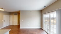 This single-floor residence offers a thoughtfully designed layout that balances open communal spaces with comfortable private areas. The living room is bright and open, featuring rich hardwood flooring, neutral warm-toned walls, and a sliding glass door that invites natural light and provides access to an outdoor balcony. An adjacent dining area flows seamlessly from the living space and connects directly to the kitchen via a peninsula with a granite countertop and an undermount double sink.

The kitchen is well-equipped with dark espresso-stained cabinetry, granite countertops, and a full suite of stainless steel appliances including a range, over-the-range microwave, and refrigerator. Recessed lighting ensures the space remains functional and well-lit.

Two carpeted bedrooms each offer a comfortable, quiet retreat with neutral walls and windows that allow natural light to filter in. The full bathroom is finished with warm beige tones, features a soaking tub with a shower and curved curtain rod, and includes chrome hardware and grab bars for added convenience.

A dedicated in-unit laundry room houses a side-by-side washer and dryer with an overhead storage shelf, adding practical everyday convenience. Consistent hardwood flooring throughout the main living areas ties the space together cohesively.