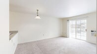 This one-bedroom, one-bathroom unit in Glendale, Wisconsin offers a practical and comfortable layout across a single floor. The welcoming entrance opens to a carpeted living room bathed in natural light from a large sliding glass door that leads directly to a private balcony, providing outdoor access and pleasant views. A wall-unit air conditioner serves the living area, and a pendant light fixture adds a classic touch to the space.

The galley-style kitchen features light wood-look flooring, white cabinetry with warm wood trim accents, laminate countertops, a stainless steel sink, and white appliances including a refrigerator, stove, and dishwasher. A pass-through counter connects the kitchen to the living and dining area, enhancing the open feel.

The bedroom is a comfortably sized retreat with soft carpeting, a large multi-pane window that brings in natural light, and a baseboard heating system. Three closets throughout the unit provide generous storage options.

The bathroom is finished with wood-look tile flooring, a wall-mounted sink, a mirrored medicine cabinet, a combined tub and shower, and grab bars for added accessibility. Neutral tones and clean lines throughout the unit create a bright, move-in-ready atmosphere.