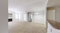 This two-bedroom, two-bathroom residence at 5500 Magnolia Run Cir in Virginia Beach, Virginia offers a functional and comfortable single-floor layout. The living room is a standout space, featuring vaulted ceilings, a ceiling fan, multiple windows that bring in natural light, and a fireplace framed by a built-in niche above — an ideal focal point for the room. Soft carpeting runs throughout the living and bedroom areas, contributing to a warm, neutral aesthetic.

The kitchen features light wood cabinetry with ample upper and lower storage, laminate countertops, wood-look vinyl flooring, and black appliances including a range and dishwasher, alongside a white refrigerator. A dedicated laundry room houses a full-sized washer and dryer.

The primary bedroom is generously sized with a ceiling fan, carpeted floors, and built-in closet shelving. The second bedroom also includes a closet with shelving and connects conveniently to the hallway. Both bathrooms include a vanity with light wood cabinetry, a mirror, and a tub-shower combination set over wood-look flooring. Two hallways provide smooth circulation throughout the residence.