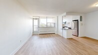 Located on the 9th floor at 765 Steeles Ave W in Toronto, this well-appointed 3-bedroom, 2-bathroom unit offers a clean, modern aesthetic across a single floor of thoughtfully laid-out living space. Light wood laminate flooring runs throughout, complementing the crisp white walls and creating a bright, airy atmosphere in every room.

The open-concept living area is generously sized, bathed in natural light through large floor-to-ceiling windows that frame outdoor views of the surrounding cityscape. This space flows seamlessly into the kitchen, which features white cabinetry, dark countertops, stainless steel appliances including a refrigerator and microwave, and a peninsula that adds both workspace and visual separation.

The primary bedroom is a spacious retreat with a large window that invites in natural light and views. The two additional bedrooms are well-proportioned, each featuring the same light flooring and clean finishes. Two closets provide additional storage throughout the unit.

Both bathrooms are finished in a clean, contemporary style. The main bathroom includes a tiled tub-shower surround with white subway tiles, a vanity with an undermount sink, and tile flooring. The second bathroom is equally well-appointed. A welcoming hallway connects all areas of the unit cohesively, completing this functional and bright Toronto residence.