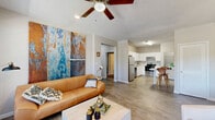 Located at 915 Lovvorn Rd in Carrollton, GA, this well-appointed single-floor home offers three bedrooms and three full bathrooms within a thoughtfully designed layout. The living room is bright and welcoming, featuring light hardwood-style flooring, a ceiling fan, recessed lighting, and large windows that invite ample natural light. A glass-paned door provides access to an outdoor area, enhancing the airy feel of the space.

The kitchen is outfitted with crisp white cabinetry, light stone countertops, and a full suite of stainless steel appliances including a refrigerator, dishwasher, range, and microwave. An in-unit washer and dryer area and a compact dining space round out the kitchen's functionality.

Each of the three bedrooms features plush carpeting, a ceiling fan, a double-door closet, and a built-in desk and shelving nook — ideal for work or study. Natural light filters in through windows with blinds in each room, creating a comfortable and practical environment.

The three full bathrooms each include a tub-shower combination with clean white surrounds and chrome fixtures, maintaining a consistent, tidy aesthetic throughout. Two connecting hallways provide smooth circulation across the home, making the overall layout efficient and easy to navigate.