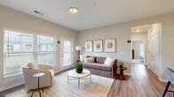 Located at 1905 Stelzer Rd in Columbus, Ohio, this 2-bedroom, 2-bathroom residence offers a thoughtfully designed single-level layout. The open-concept living and kitchen area serves as the heart of the home, where warm hardwood-style flooring flows throughout. The kitchen is equipped with sleek gray cabinetry, granite countertops, stainless steel appliances, and a peninsula island with pendant lighting and bar seating — ideal for both cooking and casual dining. The living room is bright and welcoming, benefiting from large windows with natural light and direct access to an exterior door. Two well-sized bedrooms provide comfortable retreats, each featuring plush carpet flooring and ample closet space — with four closets total throughout the unit. The primary bedroom offers a generous footprint with room for a full furniture arrangement. Both bathrooms are finished with granite vanity tops, gray cabinetry, wood-style flooring, and tub/shower combinations. Additional conveniences include a dedicated laundry room, a utility room, and a hallway connecting the private quarters. The overall aesthetic is clean and contemporary, with neutral tones throughout creating a cohesive and inviting atmosphere.