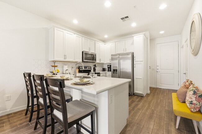 Modern, fully equipped kitchen with quartz countertops and stainless-steel appliances. - 2511 W Queen Creek Rd