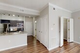Located at 701 Highland Ave NE in Atlanta's vibrant Grant Park neighborhood, this single-floor unit offers a well-designed layout that maximizes functionality across seven distinct spaces. Wood-style flooring flows throughout the main living areas, complemented by neutral gray walls, crown molding, and white trim that create a clean, modern aesthetic.

The kitchen is equipped with dark gray cabinetry, stainless steel appliances including a range, microwave, and refrigerator, and granite-style countertops that extend to a peninsula. This peninsula connects seamlessly to the dining area, facilitating an open, connected flow. The living room features a ceiling fan and multiple windows that invite natural light, lending the space an open, airy feel.

A dedicated entrance provides a welcoming transition into the unit, while the hallway offers access to the full bathroom, which includes a tub/shower combination with tile surround, a vanity with granite-style countertop, and light tile flooring. The spacious walk-in closet is outfitted with wire shelving on multiple walls, offering generous storage. A separate laundry area houses a full-size washer and dryer. The unit's efficient, thoughtfully organized layout makes excellent use of every square foot.