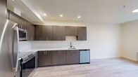 Located at 3918–3932 N Wall St in Spokane, WA, this modern 2-bedroom, 2-bathroom unit offers a thoughtfully designed single-level layout with clean, contemporary finishes throughout. Light wood-tone luxury vinyl flooring flows seamlessly across the entire space, creating a bright and cohesive aesthetic.

The kitchen is a standout feature, showcasing dark wood-grain cabinetry that extends from floor to ceiling, complemented by crisp white countertops, a matte black faucet, recessed lighting, and a full suite of stainless steel appliances including a refrigerator, range, microwave, and dishwasher. The kitchen opens naturally to the adjacent living area, supporting an open and connected feel.

Both bedrooms are well-proportioned, finished with the same light flooring and neutral walls. The primary bedroom benefits from large windows that invite generous natural light and offer views of the surrounding neighborhood. The second bedroom also features sizable windows and a ceiling fan.

Each of the two bathrooms mirrors the modern design language of the rest of the unit, with dark wood-grain vanities, white countertops, black-framed mirrors, and tub-shower combinations. Two hallways and two closets provide practical storage and circulation throughout.

Overall, the space presents a clean, minimalist aesthetic with high-quality finishes and a functional layout suited for contemporary living in Spokane.