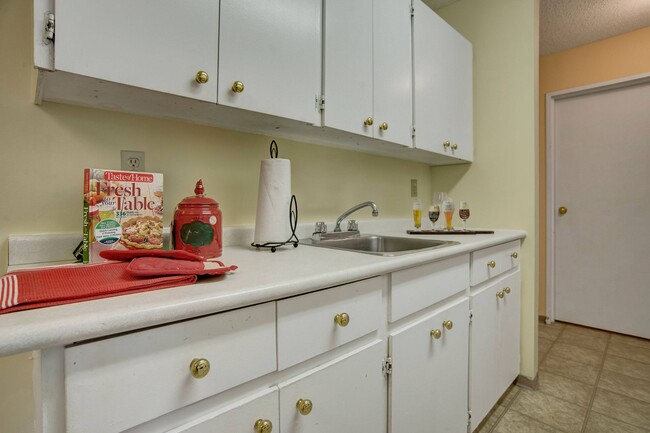 A kitchen with white appliances and white cabinetry - Tamaron Square