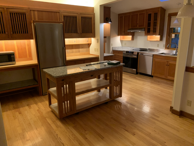 Movable island, custom cabinets, dining area behind photographer - 701 N 76th St