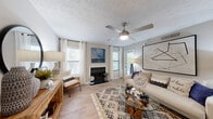 This thoughtfully designed one-bedroom, one-bathroom residence offers a comfortable and functional single-floor layout. The welcoming entryway features light wood-style flooring that flows throughout the main living areas, setting a warm tone from the moment you step inside. The open-concept living room is a standout space, highlighted by a wood-burning fireplace, a ceiling fan with integrated lighting, textured ceilings, and multiple windows that fill the room with natural light. The adjacent dining area provides an intimate setting, while the galley-style kitchen impresses with white cabinetry, granite countertops, a tile backsplash, stainless steel appliances, and a deep single-basin sink. The bedroom is a spacious retreat featuring plush carpeting, a large sliding glass door opening to a private balcony with outdoor views, and direct access to a closet with in-unit washer and dryer connections. The full bathroom includes a combined tub and shower with clean white tile surround. Neutral tones throughout create a cohesive, move-in-ready ambiance that balances comfort and practicality in every corner of this efficiently designed home.