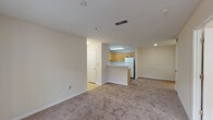 Located at 5250 Highway 138 in Union City, Georgia, this single-floor unit offers a functional and well-organized layout designed for comfortable everyday living. The open-concept living and dining area is finished with neutral-toned carpet and warm beige walls, creating a bright and welcoming atmosphere. The kitchen is situated at the heart of the space and features warm oak cabinetry, white appliances including a range, refrigerator, and dishwasher, light countertops, and a breakfast bar peninsula that connects seamlessly to the main living area. Wood-look flooring adds a durable and attractive finish to the kitchen. The bedrooms are generously sized, carpeted, and filled with natural light from multiple windows fitted with blinds. Each bedroom includes closet space, providing ample storage. One bedroom notably features a built-in desk area, adding versatility for use as a home office or study. The bathroom is well-appointed with a wide vanity, white cabinetry, a large mirror, and wood-look flooring that complements the rest of the unit. Throughout the space, clean white trim, panel-style doors, and consistent neutral tones contribute to a cohesive and tidy aesthetic. Ceiling vents ensure efficient climate control throughout.