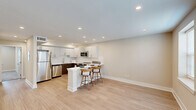 Located at 349 Chilton Ct in Plymouth Meeting, PA, this thoughtfully designed single-floor unit offers a clean, modern aesthetic throughout its two-bedroom, single-level layout. The open-concept kitchen and living area serves as the heart of the home, featuring a striking two-tone kitchen with white upper cabinetry, rich dark wood lower cabinets, a white subway tile backsplash, and a full suite of stainless steel appliances including a refrigerator, dishwasher, microwave, and range. A white peninsula with bar seating creates a natural division between the kitchen and the open living area, which is finished with light hardwood-style flooring and recessed lighting that brightens the entire space. The two bedrooms are carpeted for comfort and share a warm, neutral color palette. Each bedroom benefits from recessed lighting, and the primary bedroom includes a closet. A second closet is also available elsewhere in the unit. Natural light filters in through multiple windows fitted with blinds, with views of the surrounding neighborhood. The unit is further completed by a dedicated laundry area and a utility room, ensuring practical, everyday functionality. The overall design is clean, contemporary, and move-in ready.