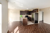 Located at 180 Mill St in London, Ontario, this well-appointed 2-bedroom, 2-bathroom unit offers a practical and comfortable single-floor layout. Rich hardwood-style flooring flows throughout the main living areas and bedrooms, complemented by neutral warm-toned walls that create a bright, welcoming ambiance.

The open-concept kitchen is a standout feature, showcasing dark espresso cabinetry with raised-panel detailing, granite countertops, a peninsula with a double stainless steel sink, and a full suite of stainless steel appliances including a refrigerator, electric range, and built-in microwave. Light tile flooring in the kitchen transitions seamlessly into the living area.

The spacious living room is bathed in natural light through large windows and a sliding glass door that opens to a balcony, offering views of the surrounding London cityscape. Both bedrooms feature the same warm hardwood-style flooring and generous windows that frame urban views.

The two bathrooms are finished with tile surrounds; one includes a tiled tub-shower combination with granite vanity countertop, while the second offers a clean tub-shower unit. A tiled entrance hallway with a built-in closet completes the layout. The unit offers a well-balanced combination of modern finishes and functional living space.