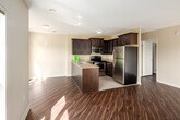 Located at 180 Mill St in London, Ontario, this well-appointed 2-bedroom, 2-bathroom unit offers a practical and comfortable single-floor layout. Rich hardwood-style flooring flows throughout the main living areas and bedrooms, complemented by neutral warm-toned walls that create a bright, welcoming ambiance.

The open-concept kitchen is a standout feature, showcasing dark espresso cabinetry with raised-panel detailing, granite countertops, a peninsula with a double stainless steel sink, and a full suite of stainless steel appliances including a refrigerator, electric range, and built-in microwave. Light tile flooring in the kitchen transitions seamlessly into the living area.

The spacious living room is bathed in natural light through large windows and a sliding glass door that opens to a balcony, offering views of the surrounding London cityscape. Both bedrooms feature the same warm hardwood-style flooring and generous windows that frame urban views.

The two bathrooms are finished with tile surrounds; one includes a tiled tub-shower combination with granite vanity countertop, while the second offers a clean tub-shower unit. A tiled entrance hallway with a built-in closet completes the layout. The unit offers a well-balanced combination of modern finishes and functional living space.