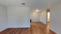 Located at 701 N Indiana Ave in Lubbock, Texas, this single-story home offers a clean, functional layout designed for comfortable everyday living. The interior showcases warm hardwood flooring that flows throughout the main living areas, adding a sense of continuity and warmth to the space. Neutral white and light gray walls provide a bright, versatile backdrop that complements a variety of décor styles. The textured ceiling adds a classic touch consistent with traditional residential construction. A partial interior wall creates a natural division between living areas while maintaining an open, connected feel. HVAC vents are integrated into the ceiling for efficient climate control throughout. White painted doors with louvered panels contribute to the home's clean, understated aesthetic. Crisp white baseboards frame each room, providing a polished finish against the hardwood floors. The overall ambiance is calm and move-in ready, with a straightforward design that prioritizes practicality and livability. Conveniently situated in a Lubbock neighborhood, this property presents a solid foundation for residents looking for a well-maintained, single-level home.