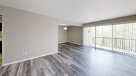 Located at 650 West Rand Road in Arlington Heights, IL, this well-appointed one-bedroom, one-bathroom unit offers a thoughtful layout across a single floor. The open living and dining area is bright and welcoming, featuring warm hardwood-style flooring, neutral gray walls, a classic chandelier, and baseboard heating. Vertical blinds lead to a private patio, extending the living space outdoors. The kitchen is equipped with warm-toned wood cabinetry, dark granite countertops, a tile backsplash, and black appliances including a full-size refrigerator and gas range. Light ceramic tile flooring and a ceiling fan complete the functional space. The spacious primary bedroom offers hardwood-style flooring, a large window with natural light, and two closets for generous storage. The bathroom features a full soaking tub and shower combination, framed by elegant large-format stone-look tile with a decorative mosaic border accent. An in-unit laundry area provides added everyday convenience. The unit's clean, neutral palette and well-maintained finishes create a comfortable and move-in-ready living environment.