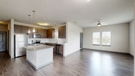 Located at 2509 Cattlemen Rd in Sarasota, Florida, this single-story, 2-bedroom, 2-bathroom residence offers a thoughtfully designed layout with modern finishes throughout. The open-concept living, dining, and kitchen area serves as the heart of the home, featuring durable wood-style flooring, a ceiling fan, and multiple windows that invite abundant natural light. The kitchen is a standout, equipped with rich dark-wood cabinetry, stainless steel appliances, a granite-topped island with pendant lighting, and a functional sink with ample counter space. A hallway with built-in shelving connects the main living area to the private quarters. Both bedrooms are generously sized, finished with plush carpeting, ceiling fans, and windows offering natural light. The primary bedroom benefits from its own dedicated closet space, and the unit includes a total of three closets for excellent storage. The bathrooms feature granite vanities with warm wood cabinetry, and one includes a tiled shower-tub combination. A dedicated laundry room with side-by-side washer and dryer adds everyday convenience. The unit also includes a private patio, completing this comfortable and functional Sarasota residence.