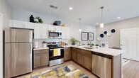 Located at 1154 N Old Castle Rd in Nixa, Missouri, this single-story, 2-bedroom, 2-bathroom home offers a thoughtfully designed layout that maximizes functionality and comfort. The open-concept kitchen and dining area is a standout feature, showcasing white upper cabinetry, warm-toned lower cabinets, a classic subway tile backsplash, stainless steel appliances, and light wood-style flooring. A peninsula counter with bar seating flows seamlessly into the dining space, which is illuminated by pendant lighting. The living room is bright and welcoming, featuring recessed lighting, a ceiling fan, and French doors that fill the space with natural light and provide outdoor views. Both bedrooms are carpeted and finished with neutral tones. The primary bedroom offers a comfortable retreat, while the secondary bedroom is versatile enough for a child's room or guest space. Each bathroom is well-finished: one features a walk-in glass shower, white vanity, and tile flooring, while the second includes a tub-shower combination and matching white cabinetry. A dedicated laundry room with side-by-side washer and dryer connections adds everyday convenience. Throughout the home, neutral wall tones and consistent finishes create a cohesive, move-in-ready atmosphere.