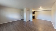This contemporary apartment offers a thoughtfully designed living space with a blend of functionality and style. The open-concept layout seamlessly connects the living areas, creating a spacious feel. The kitchen is a highlight, boasting dark wood cabinetry, stainless steel appliances, and ample counter space, perfect for culinary enthusiasts.

The bathroom features a clean, modern design with a white vanity, large mirror, and a combination tub-shower unit. Bedrooms are generously sized, some with plush carpeting for comfort, while others maintain the sleek hardwood flooring found throughout the main living areas.

Large windows in various rooms allow natural light to flood the space, enhancing the neutral color palette and creating a bright, airy ambiance. The apartment's design emphasizes clean lines and minimalist aesthetics, providing a blank canvas for personal style.

Storage solutions are integrated throughout, including closet spaces and kitchen cabinetry. The overall layout promotes easy flow between rooms, making it ideal for both everyday living and entertaining. This apartment combines modern amenities with a versatile living space, appealing to those seeking a contemporary urban lifestyle.