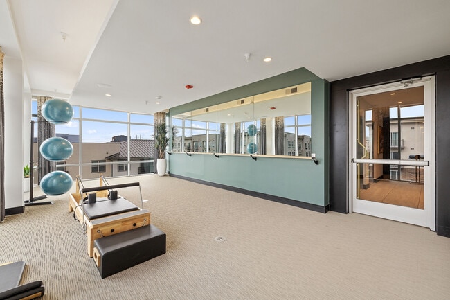 Sala de yoga con reformers y barra de pilates - The Grand at the Domain