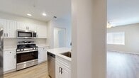 This 2-bedroom, 3-bathroom single-floor residence in Rancho Cucamonga, CA offers a well-designed layout with modern finishes throughout. The kitchen is a standout feature, showcasing white shaker-style cabinetry with matte black hardware, light quartz countertops, a peninsula with an undermount sink, and a full suite of stainless steel appliances including a gas range, microwave, dishwasher, and refrigerator. Light wood-look flooring extends through the kitchen and living areas, adding warmth and continuity. The living room is bright and open, featuring a ceiling fan and a window that allows natural light to fill the space. The primary bedroom offers generous proportions, plush carpeting, a ceiling fan, and sliding glass doors that open to a private balcony with outdoor views. The second bedroom is carpeted with a double-door closet and ample natural light. The bathrooms maintain the clean aesthetic of the home, with white vanities, wood-look flooring, and a tub-shower combination. A hallway connects the bedrooms and bathrooms, providing a practical flow throughout the residence. The overall ambiance is clean, bright, and move-in ready, with contemporary finishes and a cohesive neutral palette.