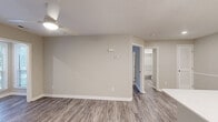 Located at 7100 Claxton Cir in Raleigh, NC, this well-appointed 1-bedroom, 2-bathroom single-floor unit offers a thoughtfully designed layout that maximizes every square foot. Durable hardwood-style flooring flows consistently throughout the entire space, tying each room together with a clean, modern aesthetic. Neutral gray-toned walls and crisp white trim create a bright, welcoming atmosphere throughout.

The open-concept living, dining, and kitchen area serves as the heart of the home. The kitchen is outfitted with white shaker cabinetry, white quartz countertops, stainless steel appliances including a range, microwave, dishwasher, and refrigerator, and a peninsula with a stainless steel sink — ideal for both cooking and casual dining.

The bedroom is generously sized, featuring a ceiling fan, large windows with blinds that invite natural light and outdoor views, and a double-door closet for ample storage. The unit includes five closets in total, providing exceptional storage throughout.

Both bathrooms are finished with white cabinetry, quartz countertops, and hardwood-style flooring. One features a large vanity with a framed mirror and a separate tub/shower, while the second includes a compact corner shower. A dedicated laundry area adds everyday convenience to this practical and comfortable Raleigh residence.