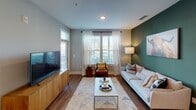 Located at 12009 Lemmond Farm Dr in Mint Hill, NC, this single-floor residence offers a thoughtfully designed open-concept layout with contemporary finishes throughout. The living room makes a strong impression with warm hardwood-style flooring, a bold green accent wall, and large windows dressed in sheer white curtains that flood the space with natural light. The kitchen is a standout, featuring slate-gray shaker cabinetry, a white subway tile backsplash, granite countertops, stainless steel appliances, and a peninsula island with pendant lighting — ideal for both cooking and casual dining. A built-in mudroom nook near the entry adds practical storage. The bedrooms continue the home's modern aesthetic, each featuring plush carpeting, bold accent walls in deep navy, and windows with exterior views that bring in ample daylight. The bathroom is well-appointed with matching gray cabinetry, granite countertops, hardwood-style flooring, and convenient access to a walk-in closet. Throughout the residence, a cohesive color palette of grays, deep greens, and navy blues is balanced by warm wood tones and bright, well-lit spaces, creating an inviting and functional living environment.