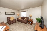 Located at 1475 Second St in Coralville, Iowa, this two-bedroom, one-bathroom unit offers a practical and well-organized single-floor layout. The carpeted living room serves as the central gathering space, featuring a large window that brings in natural light and provides an open, welcoming atmosphere. A hallway connects the living area to the rest of the unit, offering a clear and functional flow throughout.

The kitchen is outfitted with stainless steel appliances — including a range, over-the-range microwave, dishwasher, and refrigerator — complemented by taupe cabinetry and light countertops. Durable wood-look flooring runs through the kitchen and dining area, where a small dining set fits neatly alongside the cabinetry. The kitchen connects conveniently to the main living areas.

Both bedrooms are carpeted and feature textured ceilings consistent with the rest of the unit. The primary bedroom includes a built-in closet and is comfortably sized for standard bedroom furnishings. The second bedroom offers a window with an outdoor view, adding natural light to the space. The shared bathroom includes a vanity with wood cabinetry, a tub-shower combination, and wood-look flooring, providing a clean and functional design.