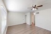Located in Baton Rouge, Louisiana, this one-bedroom, one-bathroom residence offers a well-organized single-floor layout designed to maximize every square foot. Consistent wood-look flooring runs throughout the living areas and bedroom, providing a clean, cohesive aesthetic against crisp white walls and bright white trim.

The living room is an open, airy space illuminated by natural light from a window with blinds and equipped with a ceiling fan with light kit—a practical feature repeated in the bedroom as well. The layout flows naturally from the living area toward the bedroom and bathroom beyond.

The galley-style kitchen is efficiently designed, featuring white cabinetry with matte black hardware, light countertops, a stainless steel double-basin sink, and black appliances including a coil-top range, range hood, and refrigerator—making smart use of the available space.

The spacious primary bedroom offers a comfortable, versatile footprint with a ceiling fan, a closet, and direct access to the bathroom. The bathroom is a standout feature, highlighted by large-format marble-look porcelain tile surrounding a soaking tub, adding an elevated, polished touch. White cabinetry with ample storage completes the space. Overall, this residence offers a clean, updated, and functional living environment.