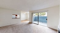 Located at 1320 S Victoria Ave in Oxnard, California, this 2-bedroom, 2-bathroom single-floor residence offers a practical and comfortable layout throughout. The living room serves as the heart of the home, featuring plush carpeting, a classic fireplace, and a textured ceiling. Large sliding glass doors open directly onto a private patio, filling the space with natural light and providing easy access to the outdoors. A ceiling fan in the adjacent dining area adds comfort, while a pass-through window connects seamlessly to the kitchen. The galley-style kitchen is outfitted with warm wood cabinetry, laminate countertops, a double-basin sink, and white appliances including an electric range, dishwasher, and microwave, all set atop light hardwood flooring. Both bedrooms are well-proportioned, featuring wood-look flooring and windows fitted with vertical blinds that offer natural light and privacy. The primary bedroom includes its own dedicated closet space. Each of the two bathrooms is finished with a full tub-and-shower combination and mirror. A dedicated laundry area and multiple closets throughout add to the home's practical storage offerings. The overall ambiance is clean, bright, and move-in ready.
