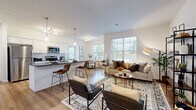 Located at 40 Red Mill Rd in Etters, PA, this well-appointed single-floor residence offers a thoughtfully designed layout comprising one bedroom, two full bathrooms, a dedicated office, and an in-unit laundry room. The open-concept kitchen is a standout feature, outfitted with white shaker cabinetry, dark granite countertops, a subway tile backsplash, stainless steel appliances, and a peninsula with pendant lighting — all flowing seamlessly into the dining and living areas. The dining space benefits from natural light through a large window with exterior views, while the living room offers a comfortable, open atmosphere with warm hardwood-style flooring throughout the main areas. The spacious primary bedroom features plush carpeting and direct access to a dedicated walk-in closet. Both bathrooms are finished with white vanities and hardwood-style flooring. The dedicated office is bright and windowed, ideal for remote work or a flex space. A separate laundry room accommodates a full-size washer and dryer with additional shelving for storage. Clean white walls and consistent finishes throughout lend the space a cohesive, modern aesthetic.