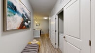 This well-appointed one-bedroom, one-bathroom residence in Nashville, TN offers a thoughtfully designed single-floor layout with wood-style flooring throughout the main living areas. The welcoming hallway entry leads into an open-concept kitchen and living room, where a granite-topped island with bar seating serves as the focal point. The kitchen is equipped with stainless steel appliances — including a refrigerator, range, and microwave — complemented by dark espresso cabinetry and ample counter space. The living area benefits from generous natural light, courtesy of large windows and a glass door that opens to an outdoor view of surrounding greenery. The bedroom features plush carpeting, a window, and access to a spacious walk-in closet with built-in shelving. The full bathroom includes a tub/shower combination, granite vanity with dark cabinetry, and wood-style flooring. Practical amenities include a dedicated in-unit laundry closet with a full-size washer and dryer, a pantry, a utility room, and three closets throughout. Neutral gray tones and clean white trim create a cohesive, modern aesthetic across the entire space.