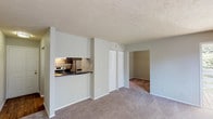 Located at 7477 Shady Water Lane in Dayton, Ohio, this single-floor unit offers a practical and well-organized layout designed for comfortable everyday living. The open living area is finished with plush wall-to-wall carpeting and neutral-toned walls, creating a clean, inviting atmosphere throughout. A textured ceiling adds a classic touch consistent across the main living spaces. The kitchen is configured in a efficient galley style, featuring dark cabinetry with ample upper and lower storage, dark countertops, wood-look flooring, and stainless steel appliances including a refrigerator and an electric range. A pass-through opening connects the kitchen to the living area, enhancing the sense of openness. The living space flows seamlessly into an additional carpeted room, accessible through an open doorway, which provides flexibility for use as a bedroom or additional living space. A double-door closet along the hallway offers generous built-in storage. The bedroom is generously sized and features a large sliding glass window that invites natural light and provides views of the surrounding greenery. The bathroom includes a shower-tub combination and a clean, simple finish. Overall, the unit presents a straightforward, functional design well-suited for single-level living.