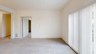 Located at 436 Broadway in downtown Tacoma, Washington, this two-bedroom, one-bathroom unit offers a efficiently designed single-floor layout. The galley-style kitchen is equipped with stainless steel appliances, including a refrigerator, electric range, and built-in microwave. Light wood cabinetry pairs with a white countertop peninsula that doubles as a breakfast bar, illuminated by pendant lighting overhead. Wood-look flooring runs throughout the kitchen, while track lighting provides additional functionality.

Both bedrooms feature neutral carpet, clean white walls, and windows with horizontal blinds that offer views of the surrounding downtown Tacoma streetscape. The primary bedroom includes a mirrored sliding closet, providing practical storage. The second bedroom also benefits from natural light through a similarly sized window. An additional room features an open closet with a built-in hanging rod.

The bathroom is well-appointed with a vessel sink atop a light wood vanity with drawer storage, a tub-shower combination, and warm wood-look flooring. A notable feature is the in-unit stacked washer and dryer, visible within the bathroom area. The overall aesthetic throughout is clean and contemporary, with a neutral color palette and consistent modern finishes.