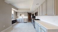 Located in the heart of downtown Columbus at 50 W Broad St, this single-floor residence offers a thoughtfully designed layout with upscale finishes throughout. The spacious kitchen is a standout feature, showcasing floor-to-ceiling grey cabinetry with gold hardware, white quartz countertops, a white subway tile backsplash, and stainless steel appliances including a gas range, built-in microwave, refrigerator, and dishwasher. Large-format marble-look porcelain tile floors add a polished, cohesive aesthetic to the kitchen and adjoining areas.

The bedrooms feature neutral-toned carpet and windows with roller shades that frame elevated views of the Columbus skyline. Built-in ledge detailing along the windows provides an architectural accent. Each bedroom is complemented by a generously sized walk-in closet outfitted with wire shelving systems and carpeted flooring for practical storage.

Two full bathrooms serve the residence. One features a soaking tub with marble-surround tile and a sage-toned vanity, while the other offers a walk-in marble tile shower with glass enclosure and a light grey vanity with quartz countertop. Both bathrooms include warm-toned tile flooring. The overall ambiance is clean, modern, and polished throughout.