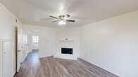 Located in Garland, TX, this two-story, 2-bedroom, 2-bathroom home offers a practical and well-organized layout spread across two floors. The main level features a welcoming living room highlighted by a white-painted brick corner fireplace, wood-look flooring, and a ceiling fan with light fixture. Natural light filters in through a window near the front entry door, lending a bright, clean atmosphere. The lower level also includes a kitchen equipped with white cabinetry, light countertops, a stainless steel sink, a dishwasher, and wood-look flooring throughout. A second kitchen space on the upper floor mirrors this design with white cabinets, a full-size refrigerator, electric range, and a double sink. Both kitchens are efficiently laid out and share a cohesive, clean aesthetic. The two bedrooms are located upstairs and feature plush carpeting, ceiling fans, and windows with blinds that allow natural light. The primary bedroom offers generous proportions and dual closets with bifold doors, providing ample storage. Both bathrooms are finished in crisp white tones, with one featuring a tub-shower combination, overhead cabinetry, and wood-look flooring. A staircase connects the two levels, with a hallway providing easy access to all upper-floor rooms.