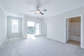 This single-floor residence offers a thoughtfully designed open-concept layout that seamlessly connects the living area and kitchen. The living space features soft carpeting, crown molding, a ceiling fan, and French doors that open to a private balcony overlooking well-maintained landscaping and a brick exterior courtyard, allowing generous natural light to fill the room.

The kitchen is equipped with rich cherry wood cabinetry, granite countertops, and black appliances including a refrigerator, range, and microwave. A peninsula with corbel-supported overhangs provides additional seating and defines the kitchen from the living space, while elegant pendant lighting adds a warm, functional glow.

The bedrooms are carpeted and bright, each featuring windows with outdoor views and crown molding. One bedroom includes access to the balcony through a glass door. Closet space is generous, with at least one room offering a full-width wire shelving system for organized storage.

The bathroom features tile flooring, granite-topped cherry wood vanity cabinetry matching the kitchen, and a clean, functional layout. Throughout the residence, a consistent warm neutral color palette, tile flooring in common areas, and quality trim details create a cohesive and inviting atmosphere.
