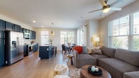 Located at 265 E State St in the heart of downtown Columbus, Ohio, this thoughtfully designed single-floor residence offers a seamless blend of modern style and functional living. The open-concept layout connects the living, dining, and kitchen areas into one cohesive, light-filled space. Large windows throughout invite abundant natural light and frame views of the surrounding cityscape, while wood-style flooring flows throughout the main living areas, adding warmth and continuity.

The kitchen is a standout feature, showcasing bold navy cabinetry paired with stainless steel appliances, granite countertops, a herringbone tile backsplash, and a central island with bar seating — ideal for both cooking and entertaining. The adjacent dining area comfortably accommodates a round table and chairs, bathed in natural light from a large window overlooking the street.

The living room is generously proportioned, anchored by a ceiling fan, large windows with city views, and wall-mounted TV provisions. The bedrooms offer a calm retreat with plush carpeting, closet storage, and bright windows with urban views. The bathroom is well-finished with dark cabinetry, granite counters, and a glass-enclosed walk-in shower. An in-unit laundry area adds everyday convenience to this polished downtown residence.