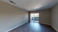 Located at 2021 N Milpitas Blvd in Milpitas, California, this single-floor unit offers a clean, modern aesthetic with thoughtfully updated finishes throughout. The open living area is finished with dark hardwood-style flooring and neutral-toned walls, creating a warm and versatile backdrop. Sliding glass doors lead to a private balcony, allowing natural light to flow in while offering pleasant outdoor views of the surrounding landscape.

The kitchen is a standout feature, designed in a galley layout with ample cabinetry in a stylish gray-blue finish, white quartz countertops, and a classic subway tile backsplash. Stainless steel appliances — including a range, microwave, refrigerator, and dishwasher — complete this well-equipped space. Light wood-tone flooring in the kitchen provides a clean contrast to the rest of the unit.

The bedroom is a comfortable, well-proportioned room featuring the same dark hardwood-style flooring and a window fitted with blinds that allows for natural light. The bathroom is finished with a distinctive blue vanity cabinet topped with a white quartz countertop and a framed mirror, paired with a full shower-tub combination. Throughout the unit, clean lines, consistent flooring, and modern fixtures create a cohesive and move-in-ready living environment.