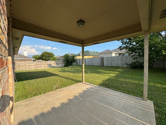 Concrete slab and roof cover shield you from Texas sun while the expansive, fenced lawn invites play - 2806 Maria Dr