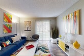 Located at 9600 E Girard Ave in Denver, CO, this well-appointed one-bedroom, one-bathroom unit offers a thoughtfully designed single-floor layout. The open-concept living, dining, and kitchen area forms the heart of the home, bathed in natural light streaming through a large sliding glass door that provides views of the outdoors. Wood-style plank flooring runs throughout the main living areas, complementing the neutral gray walls and textured ceilings. The galley-style kitchen is a standout feature, showcasing white shaker cabinetry, granite-style countertops, a classic white subway tile backsplash, black appliances including a range, refrigerator, and dishwasher, and a stainless steel sink. The entry area transitions seamlessly into the living space, which benefits from a dedicated utility room and multiple closets for ample storage. The bedroom offers carpeted flooring, a bright window with outdoor views, and direct access to the rest of the unit. The bathroom is finished with granite-topped white vanity cabinetry, wood-style flooring, and a full tub-shower combination with white tile surround. Throughout the unit, a cohesive and energetic color palette ties each space together with a modern, lively aesthetic.