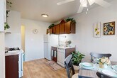 Located in Taylor, Michigan, this two-story home offers a thoughtfully organized layout spread across two floors. The main level features an open-plan kitchen and dining area with warm wood-toned cabinetry, light wood-look flooring, and white appliances including a gas range and refrigerator. A ceiling fan overhead and a large window flood the dining space with natural light, creating a bright and welcoming atmosphere. The living room impresses with vaulted ceilings that lend a sense of openness, soft carpeted flooring, and a clean, neutral color palette throughout. A staircase connects the two floors, which are also served by hallways providing easy access to all rooms. Upstairs, the spacious primary bedroom features plush carpeting, a natural window view, and ample space for furnishings. A dedicated office with a window and carpet offers a quiet, functional workspace. Two full bathrooms serve the home, one featuring a vanity with mirrored medicine cabinets and light countertops. A closet provides additional storage. The overall ambiance is light, airy, and functional, with consistent neutral tones and practical finishes throughout both floors.