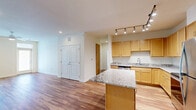 Located at 7800 Creekridge Rd in Charlotte, NC, this well-appointed three-bedroom, two-bathroom residence offers a thoughtfully designed single-floor layout. The open-concept kitchen and living area serves as the heart of the home, featuring warm maple cabinetry, granite countertops, a central island, and a full suite of stainless steel appliances including a dishwasher, range, microwave, and refrigerator. Track lighting illuminates the space, while hardwood flooring flows throughout the main living areas, adding warmth and continuity.

The three bedrooms provide comfortable retreats, with ceiling fans in each room. The primary bedroom features hardwood floors and a large window with natural light, while the secondary bedrooms are finished with plush carpeting and include ample closet space with double-door closets. Four closets in total offer generous storage throughout the residence.

The bathrooms are finished with granite-topped vanities, wood cabinetry, and hardwood flooring, with a walk-in shower in the secondary bath. Additional conveniences include a dedicated laundry room and utility room. A private balcony extends the living space outdoors, overlooking the bright exterior of the building. The residence is part of a vibrant multi-unit community in Charlotte's 28212 area.