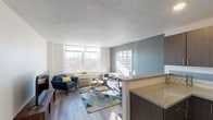 Located on E McMillan Street in Cincinnati, OH, this single-floor residence offers a thoughtfully designed layout that balances comfort and modern style. The open-concept living area is bathed in natural light streaming through large windows, which frame views of the surrounding neighborhood. Wood-look flooring runs throughout, complementing the crisp white walls and soft blue accent walls that lend the space a calm, cohesive aesthetic.

The kitchen is efficiently designed with rich dark-wood cabinetry, granite countertops, a tiled backsplash, and black appliances including a refrigerator, range, and dishwasher. A peninsula counter connects the kitchen to the living and dining areas, creating a natural flow ideal for everyday living and entertaining.

The bedroom is generously sized with a large window that fills the room with natural light. A signature blue accent wall adds depth and character, while direct access to the bathroom enhances convenience. The bathroom features white tile walls, a granite-topped vanity with dark cabinetry, and a full tub-shower combination.

Throughout the space, consistent finishes—granite surfaces, dark wood tones, and wood-look flooring—create a unified and polished interior. The overall ambiance is bright, modern, and inviting, well-suited to urban living in Cincinnati.