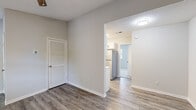 Located at 1600 W Arlington Blvd in Greenville, NC, this thoughtfully updated single-floor unit offers a clean, modern aesthetic throughout. The open layout flows seamlessly from the entry area into the living spaces, showcasing durable luxury vinyl plank flooring that runs through the main living areas. The living room stands out with vaulted ceilings and a ceiling fan, lending a sense of spaciousness and airflow, while a large window allows natural light to fill the room.

The kitchen is well-appointed with stainless steel appliances, including an electric range with a stainless steel range hood, white shaker cabinetry, elegant marble-look countertops, and a light gray subway tile backsplash — a combination that creates a bright and functional cooking space.

The bedrooms feature plush carpeting and ample natural light from large windows with blinds. One bedroom includes access to an adjacent room, ideal for use as a walk-in closet or additional storage. The bathroom is finished with a marble-look vanity countertop, an undermount sink, matte black fixtures, and wood-look flooring for a polished, contemporary feel.

Additional highlights include louvered closet doors, a textured ceiling in select areas, and a practical layout that maximizes every area of the space.