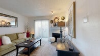 This well-organized single-story residence offers a thoughtful layout across one bedroom, one bathroom, a closet, and a combined living, dining, and kitchen area. The carpeted living room serves as the heart of the home, anchored by a classic fireplace and a sliding glass door with vertical blinds that fills the space with natural light and provides access to the outdoors. The room features a textured ceiling and offers a warm, inviting ambiance. Adjacent to the living area, a defined dining nook comfortably accommodates a four-person table, making it ideal for everyday meals. The galley-style kitchen is efficiently designed with white cabinetry, light countertops, tile flooring, and full appliances including a range and refrigerator, maximizing functionality within a compact footprint. The bedroom is a bright and comfortable retreat, highlighted by a distinctive bay window that invites natural light, soft carpet underfoot, and a ceiling fan overhead. The bathroom is clean and functional, featuring a single vanity with storage, a toilet, and a shower-tub combination. A dedicated closet provides practical storage. Throughout the residence, neutral tones and consistent finishes create a cohesive and livable atmosphere.